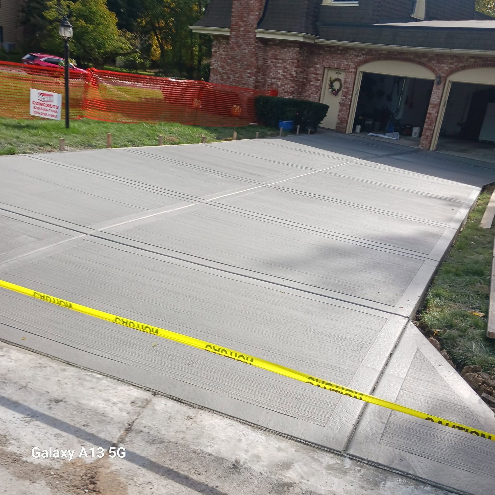 Newly poured concrete driveway with broom finish and control joints