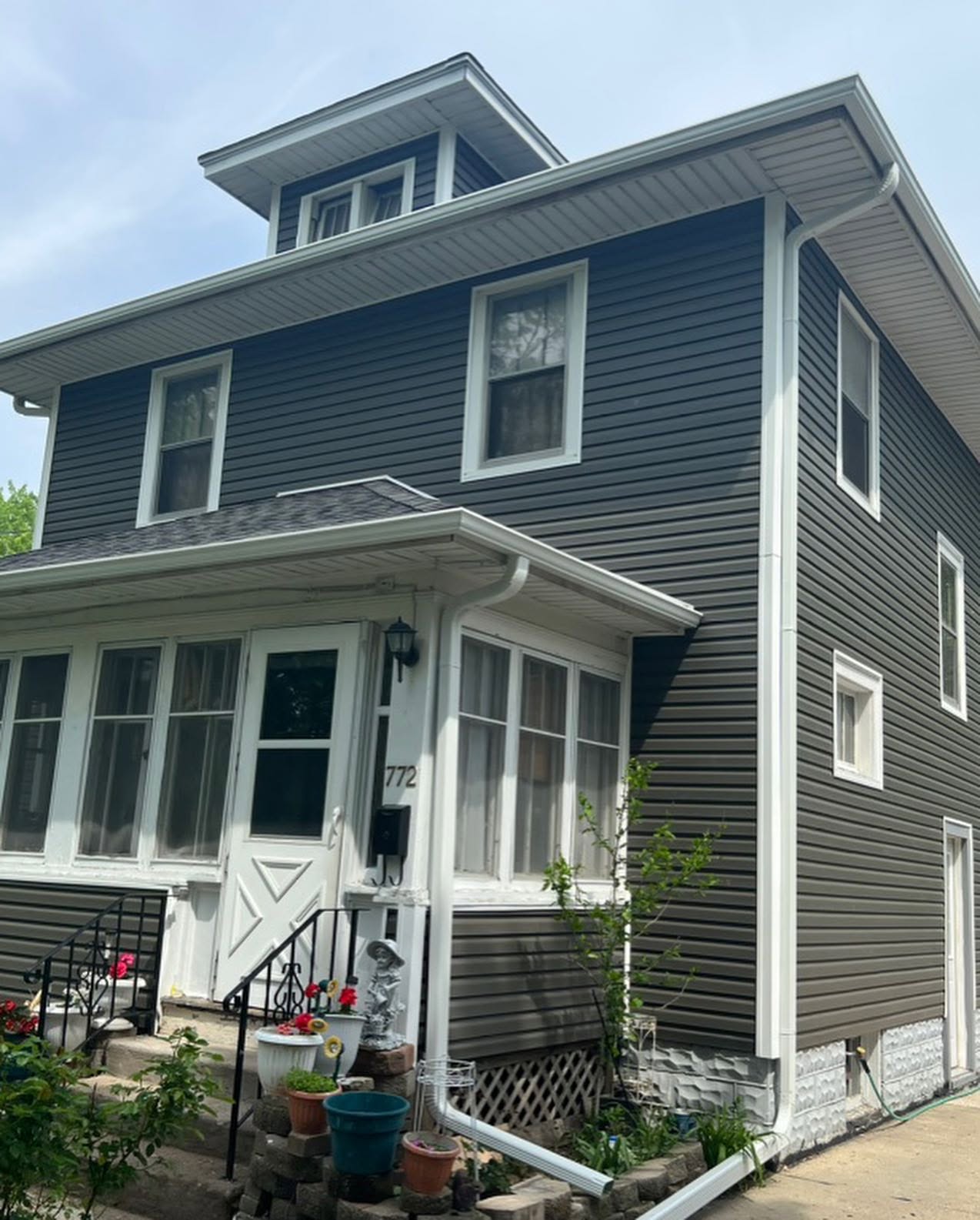 Two-story home with new navy and gray vinyl siding after replacement
